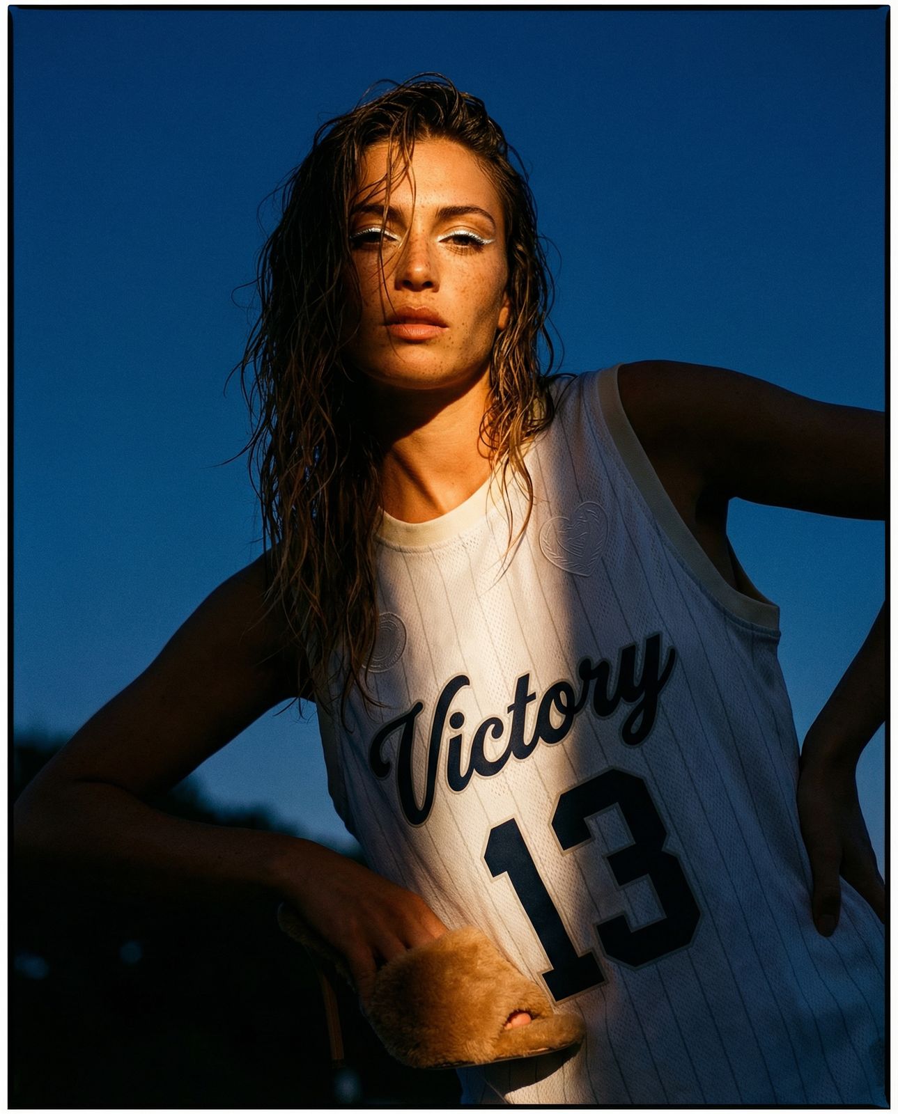 a woman in a jersey holding a baseball bat