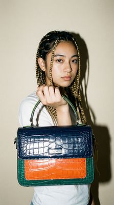a woman with braids holding a purse