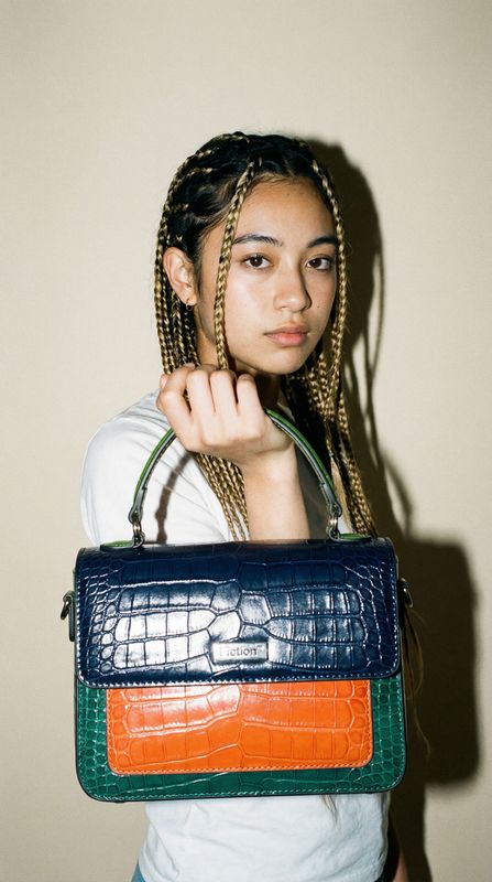 a woman with braids holding a purse
