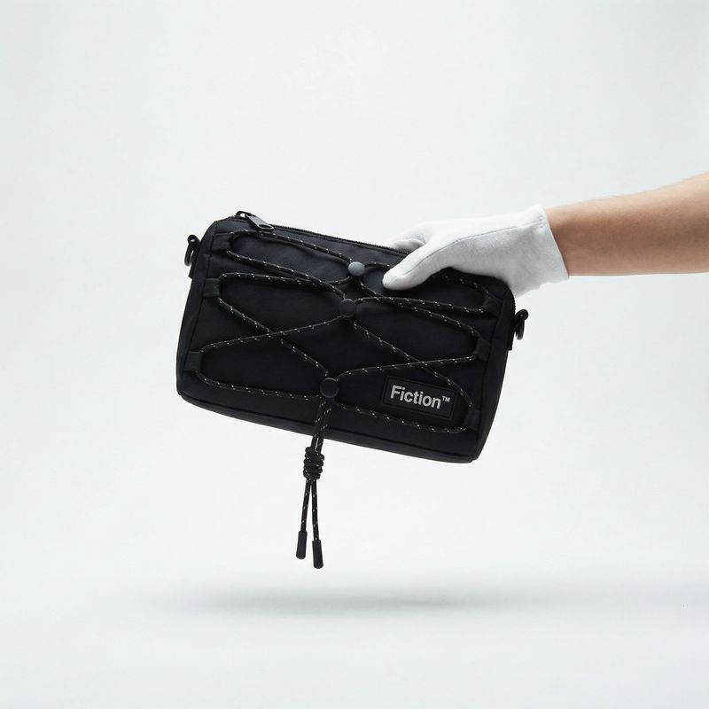 a hand in white gloves holding a black bag