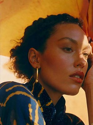 a woman talking on a cell phone while wearing earrings