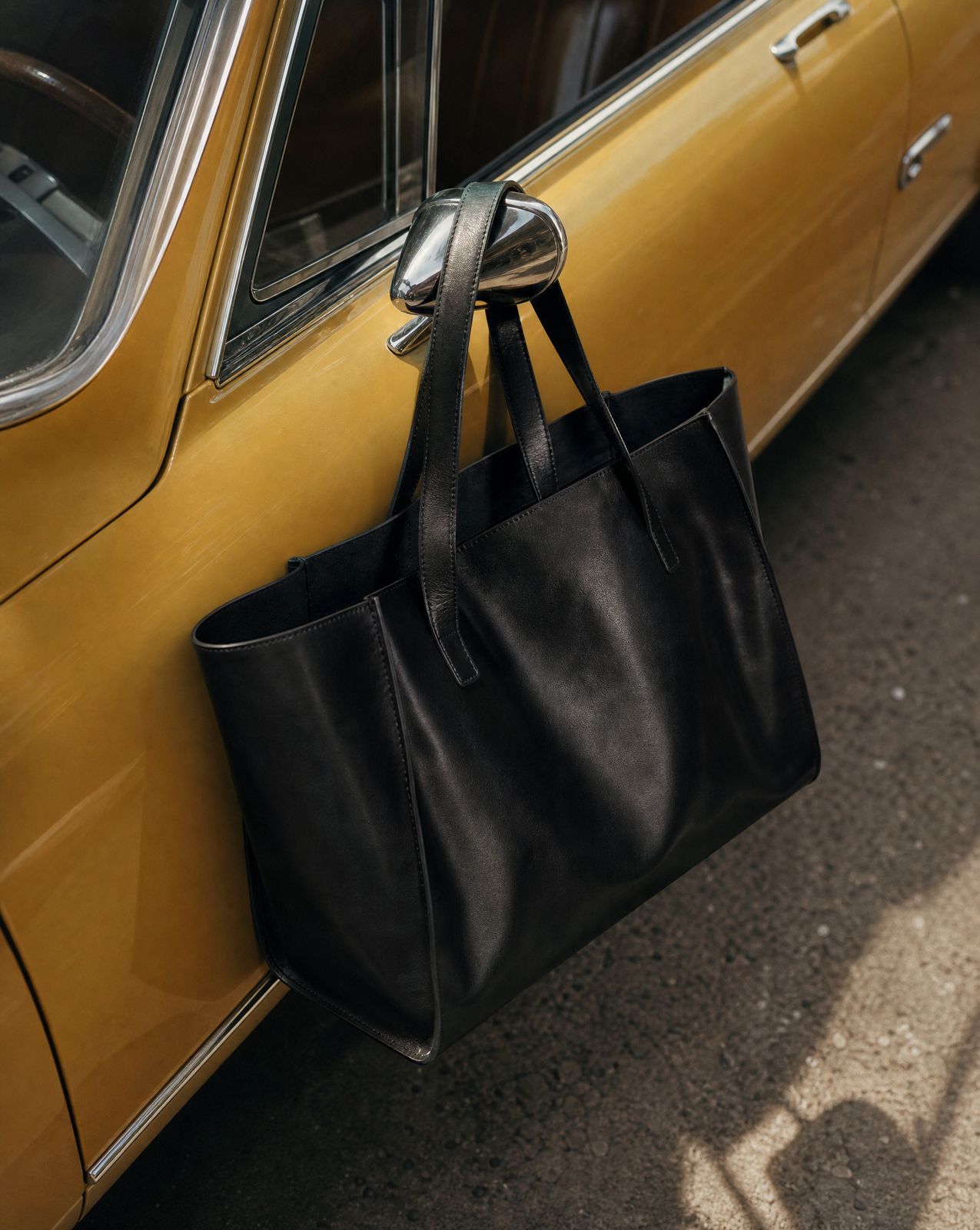 a black bag hanging from the side of a yellow car