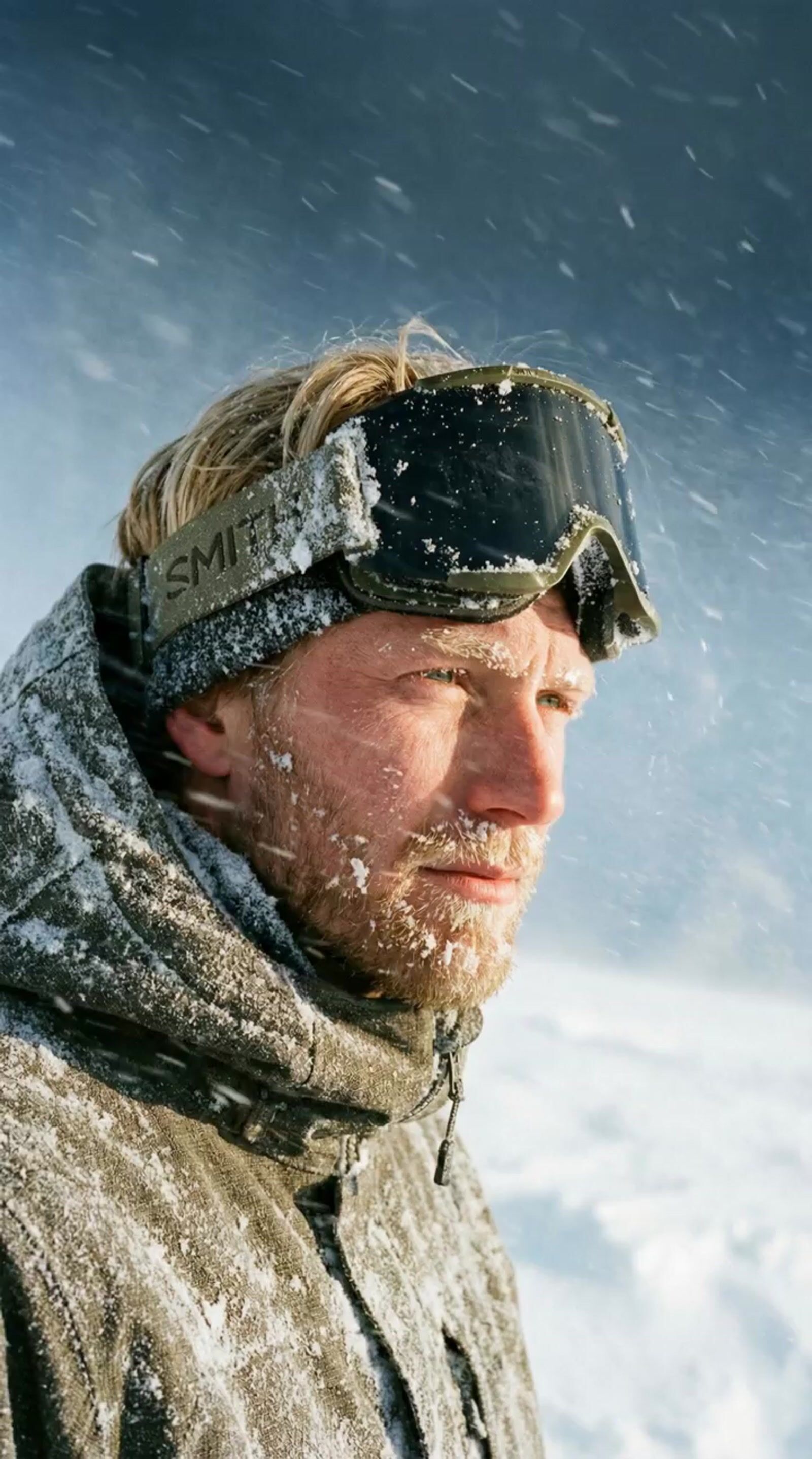a man with a beard and goggles covered in snow
