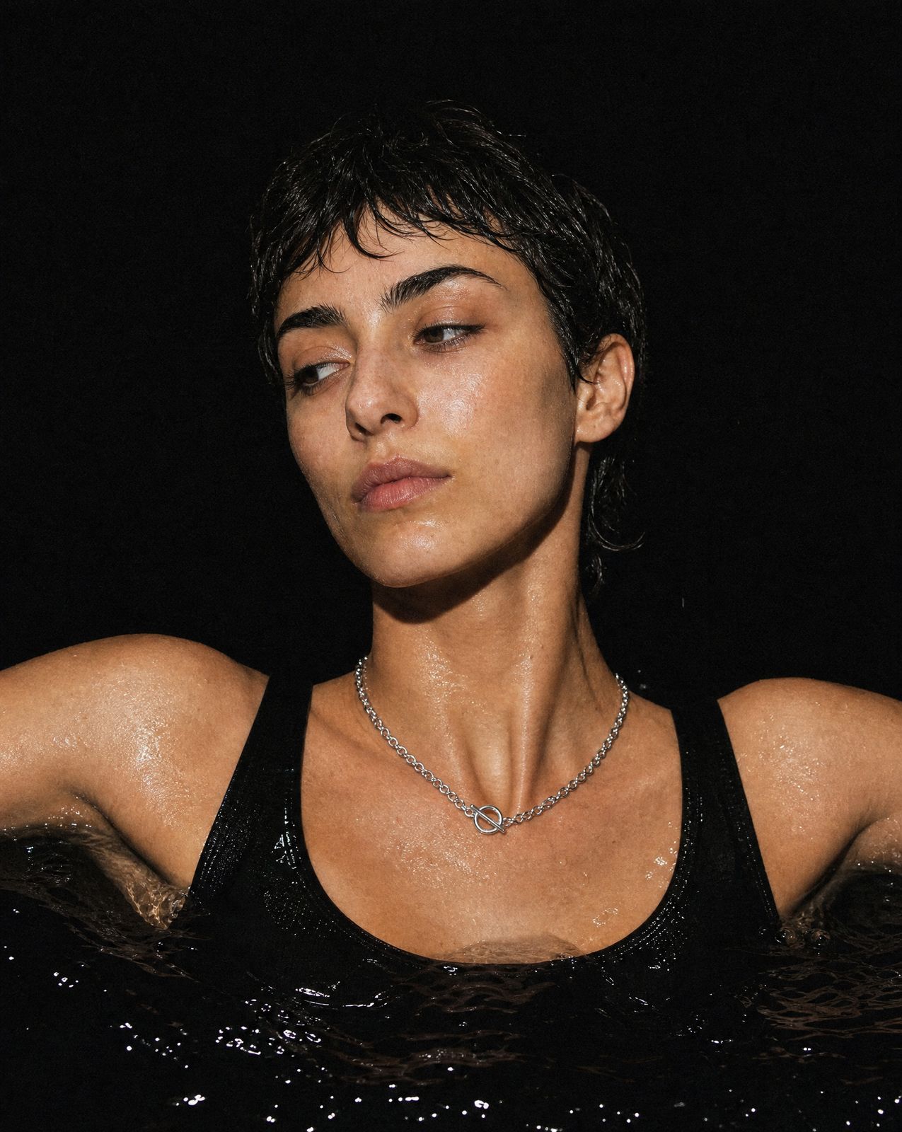 a woman wearing a black tank top and a necklace