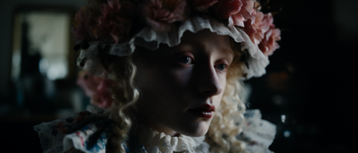 a close up of a person wearing a flowered hat