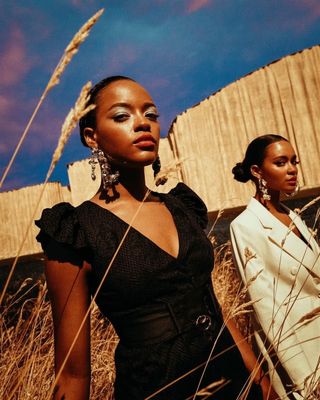 two women standing in a field of tall grass