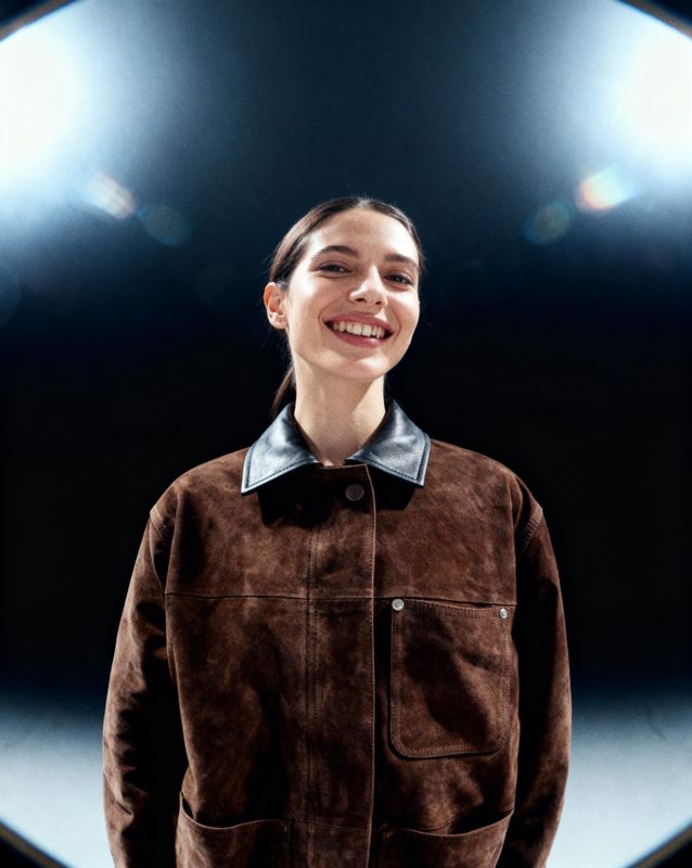 a woman standing in front of a circular light