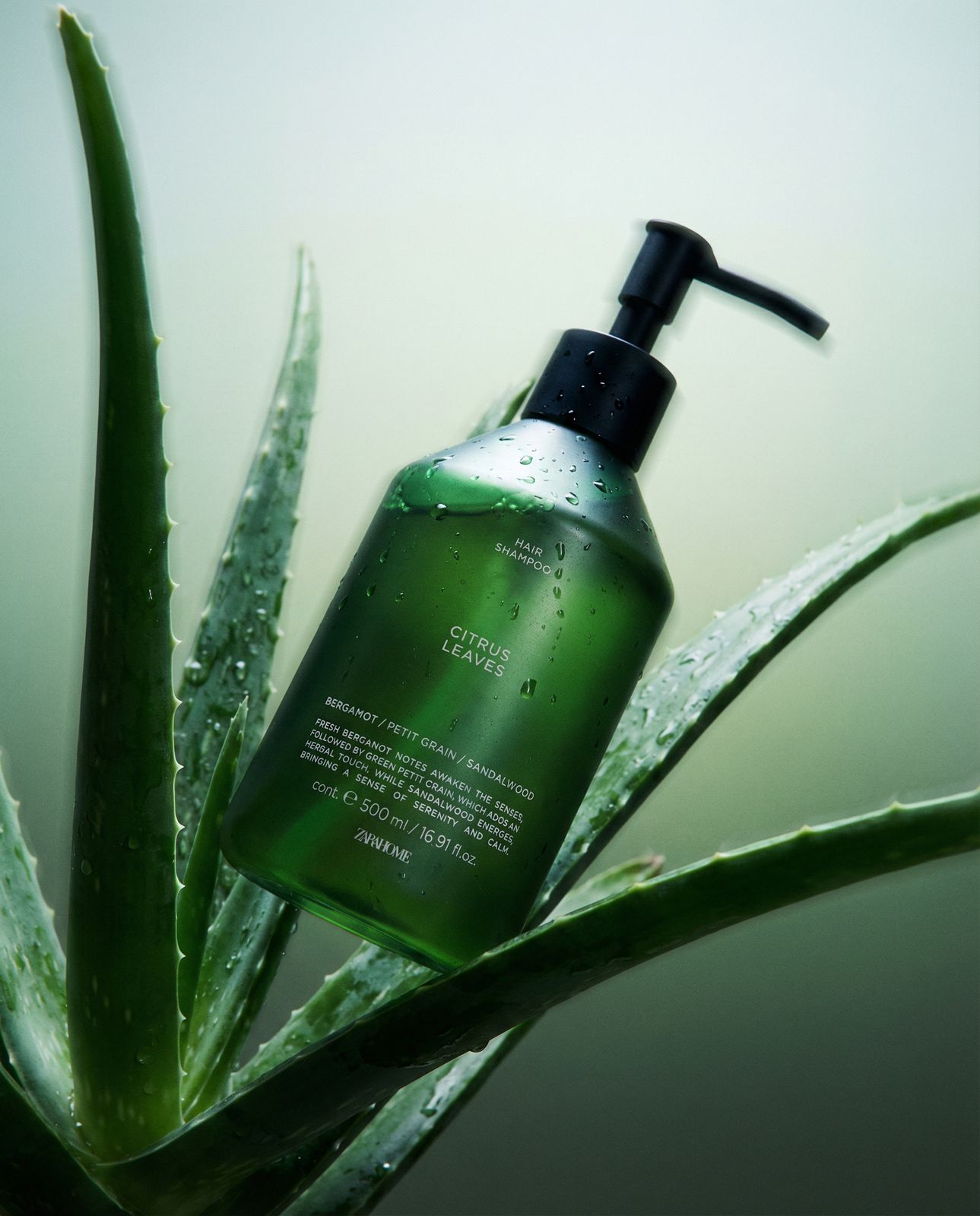 a bottle of green liquid sitting on top of a plant