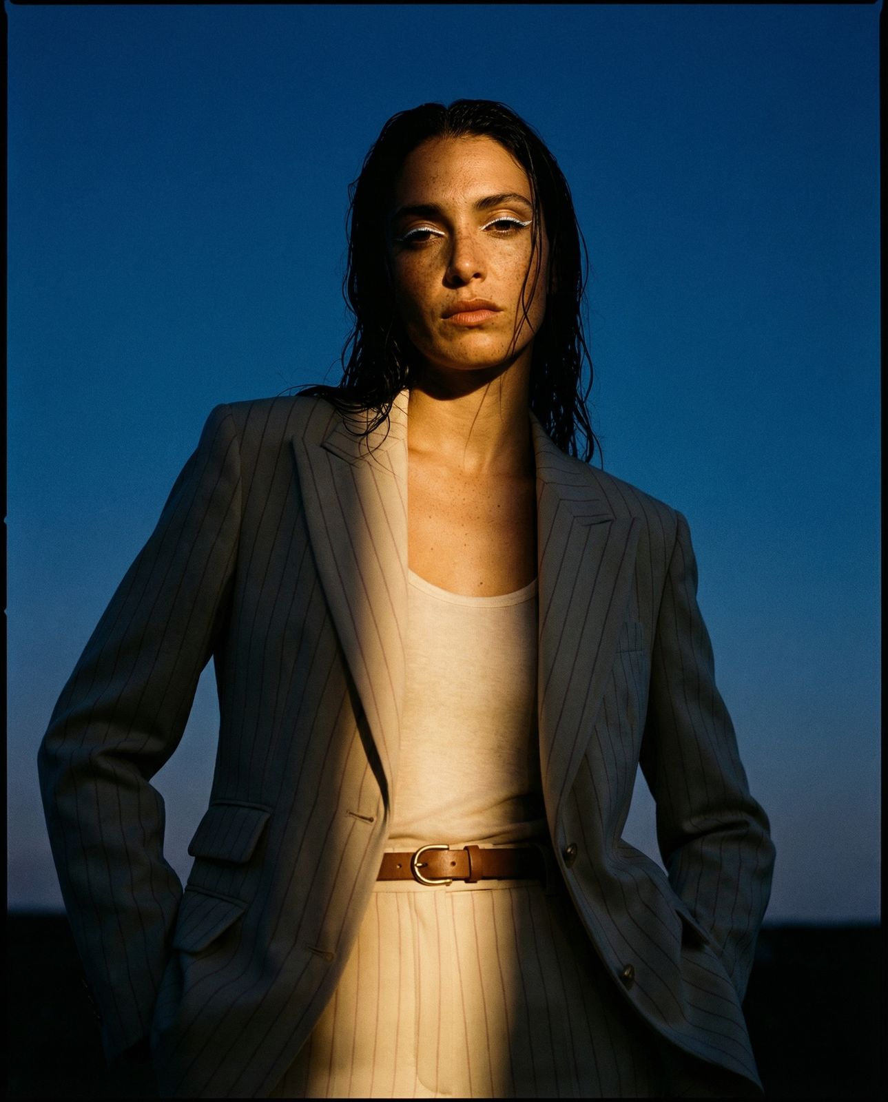 a woman in a pinstripe suit poses for a picture