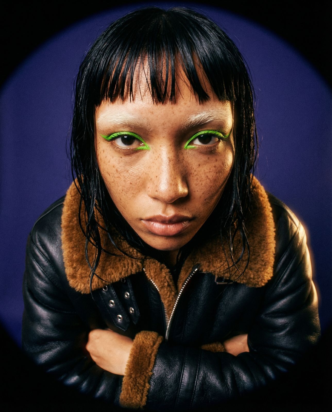 a woman with green eyes and a leather jacket