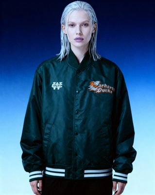 a woman with white hair wearing a green jacket