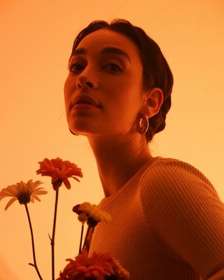 a woman holding a bunch of flowers in her hands