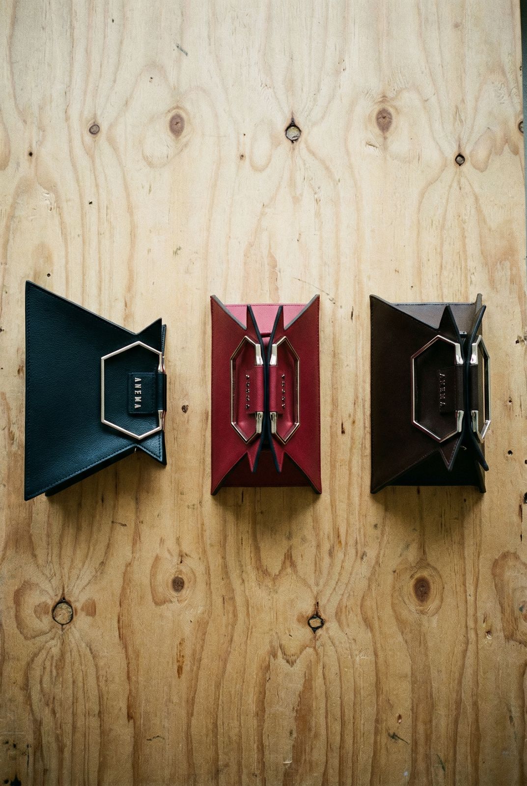 three pieces of leather are hanging on a wooden wall