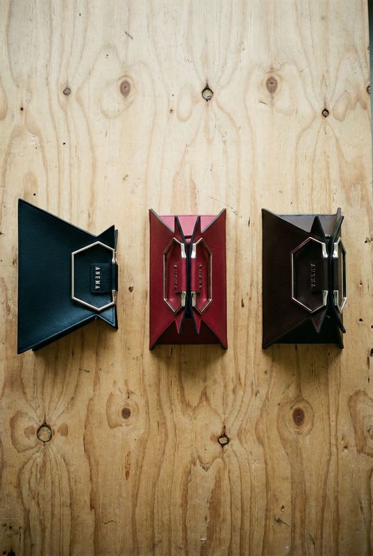 three pieces of leather are hanging on a wooden wall