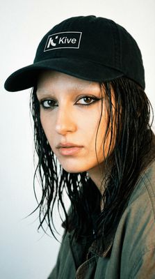 a woman with long hair wearing a black hat