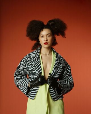 a woman in a green dress and black gloves