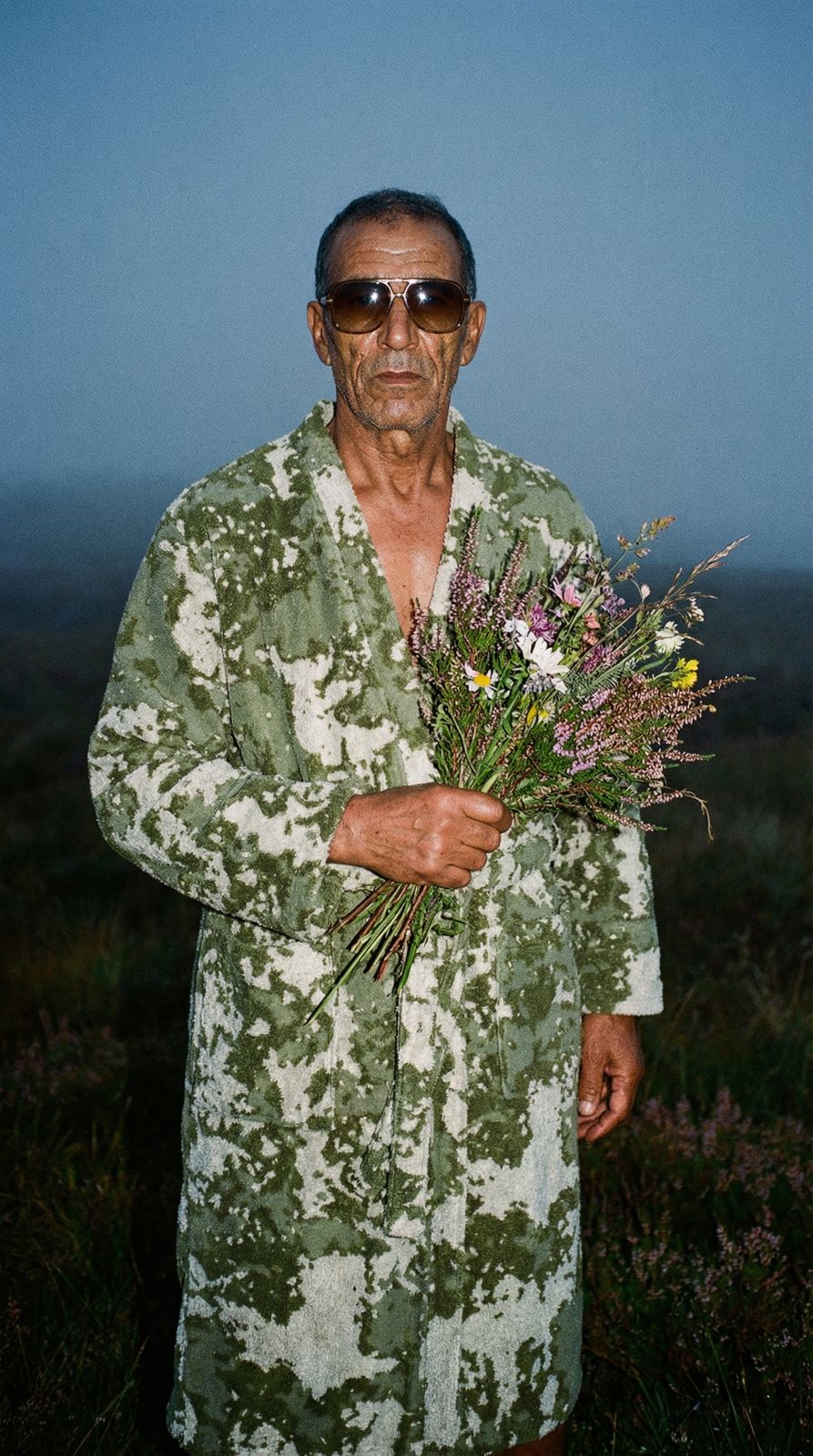 a man in a bathrobe holding a bouquet of flowers