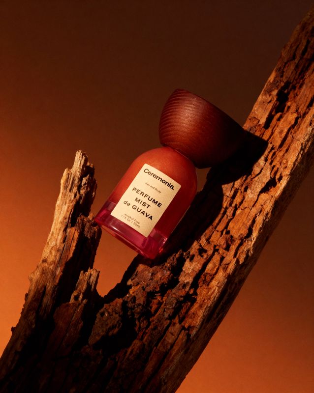 a bottle of liquid sitting on top of a tree branch