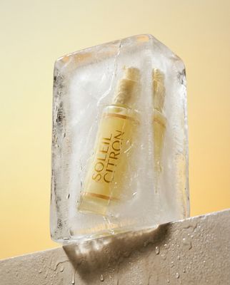 a bottle of lotion sitting on top of an ice block