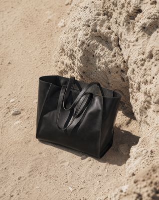 a black bag sitting on top of a sandy beach