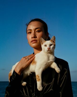a woman holding a white and orange cat