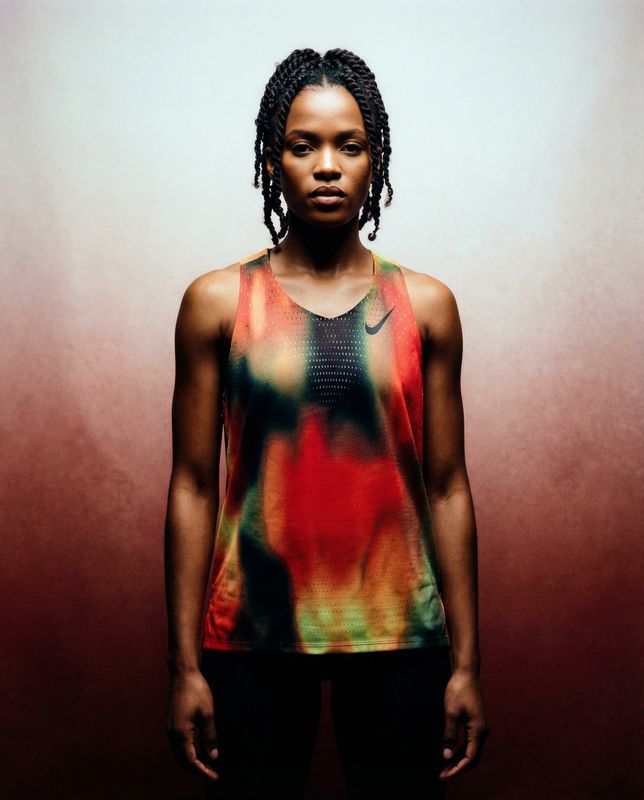 a woman with dreadlocks standing in front of a wall