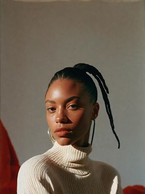 a woman wearing a white sweater and a pair of hoop earrings