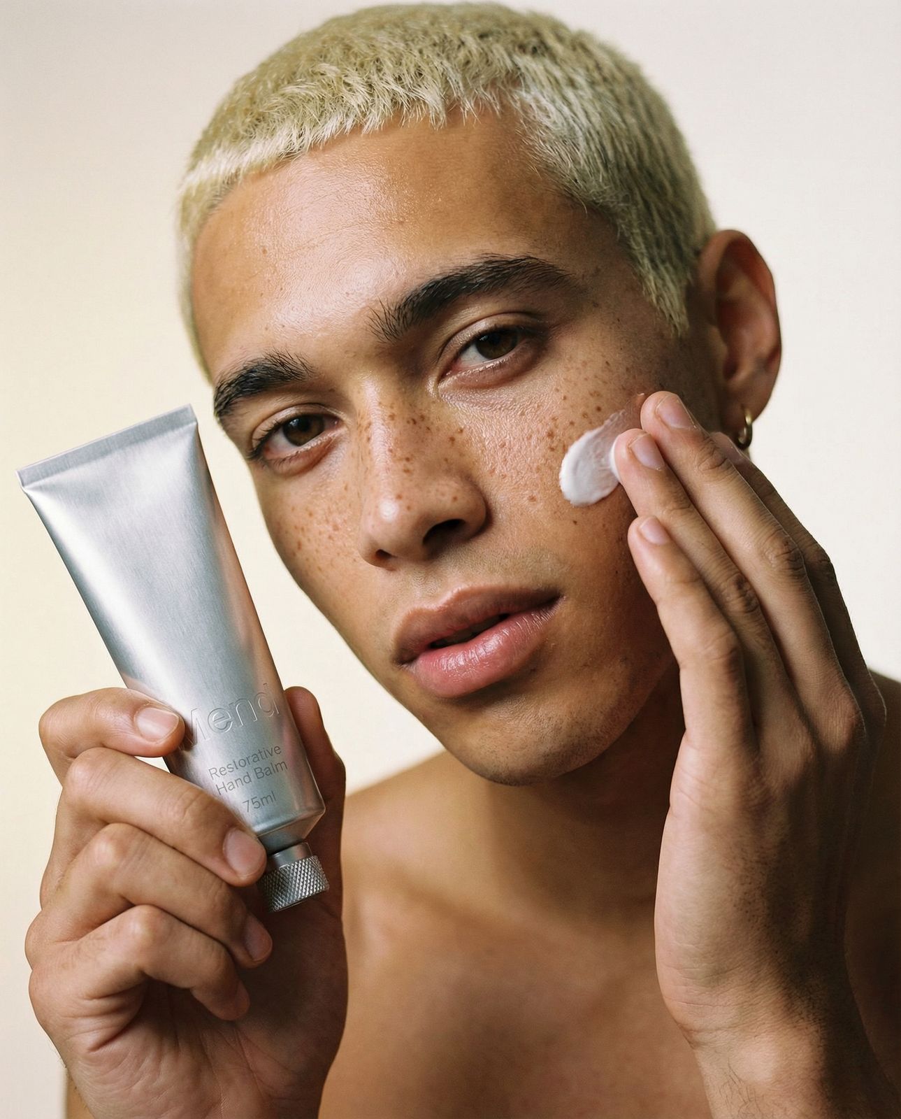 a man holding a tube of cream in his hand