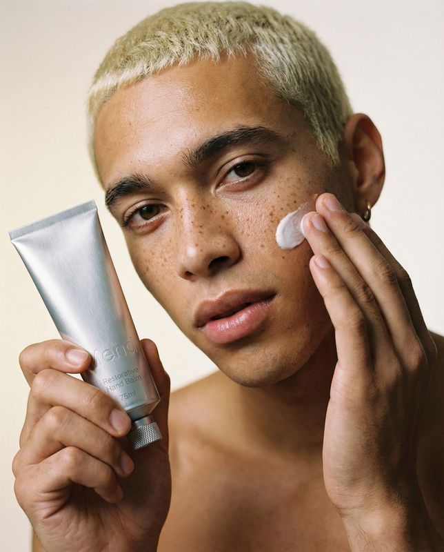 a man holding a tube of cream in his hand