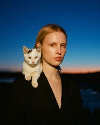 a woman with a cat on her shoulders