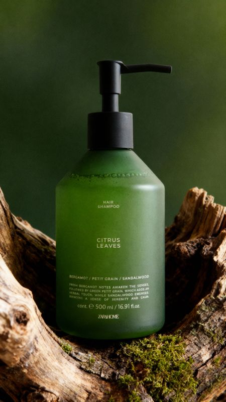 a bottle of green liquid sitting on top of a tree stump