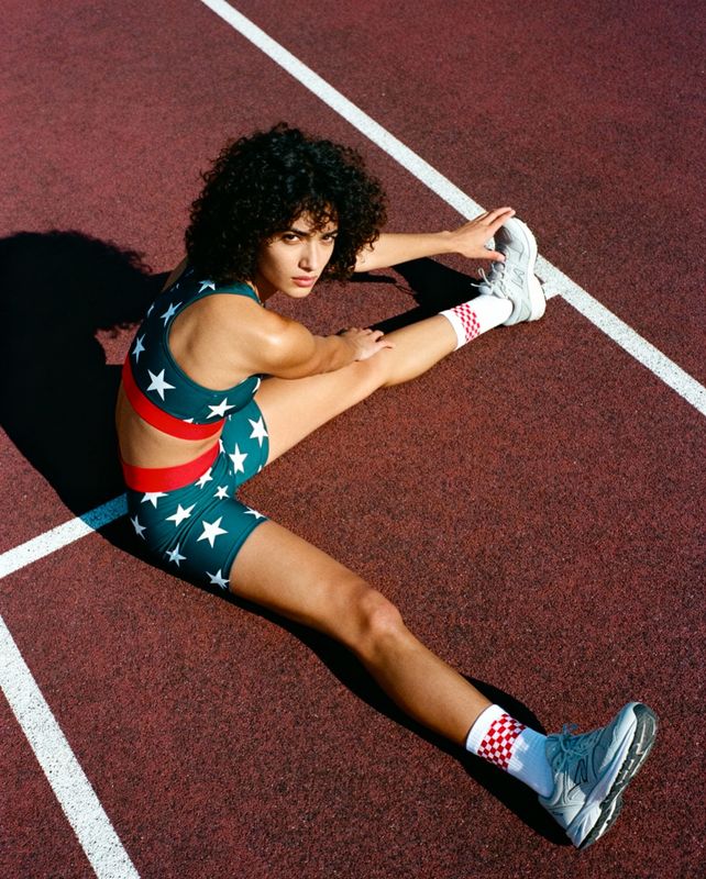 a woman sitting on a tennis court holding a racquet