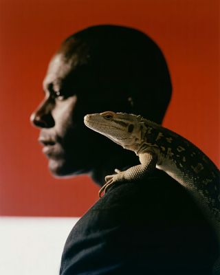 a man with a lizard on his shoulder