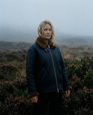 a woman standing in a field on a foggy day