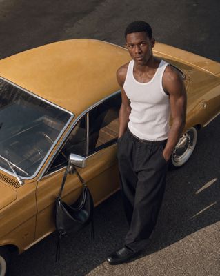 a man standing next to a yellow car