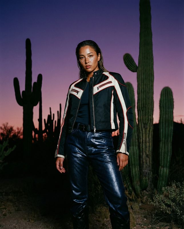 a woman standing in front of a cactus