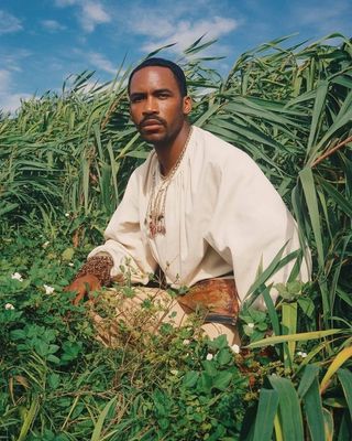 a man sitting in a field of tall grass