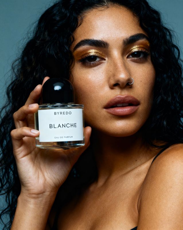 a woman holding a bottle of blanche