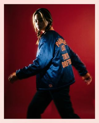 a woman in a blue jacket is walking