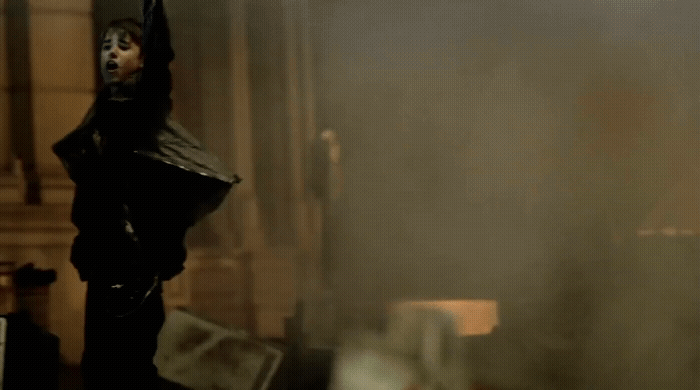 a man standing in a room with a black mask on