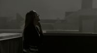 a woman standing on a balcony talking on a cell phone