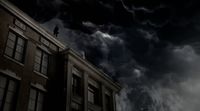a man standing on top of a building under a cloudy sky