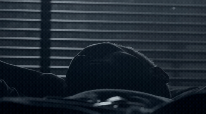 a black and white photo of a person laying in bed