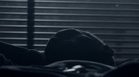 a black and white photo of a person laying in bed