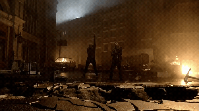 a group of people standing on a street next to a fire