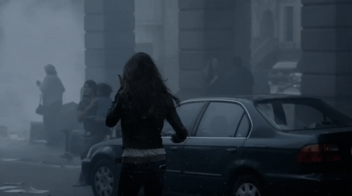 a woman walking down a street next to a car