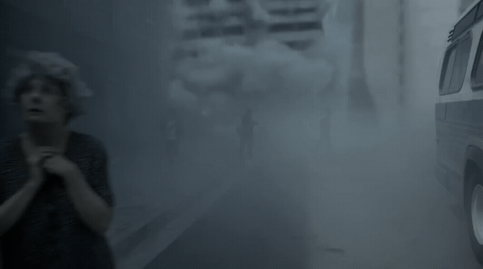 a woman standing next to a van in a foggy street