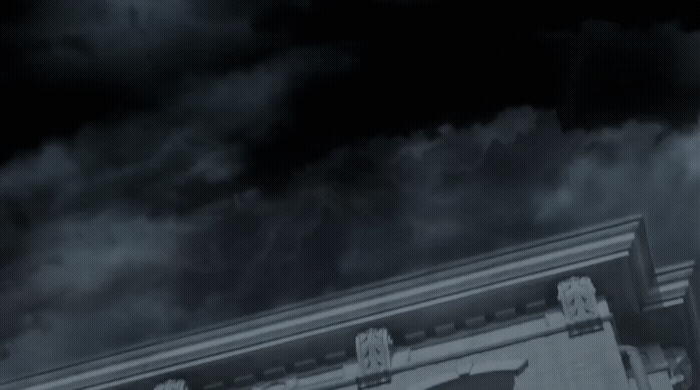 a black and white photo of a building with clouds in the background