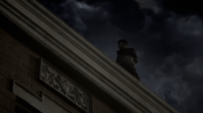 a man standing on top of a building under a cloudy sky