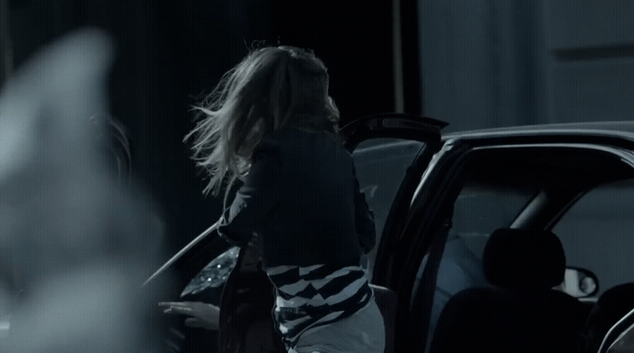 a woman getting out of a car at night